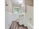 Bathroom featuring white tiled shower and bath, wood grain floor and granite topped vanity at 2184 Pemberton Sw Rd, Atlanta, GA 30331
