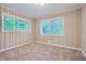 Bedroom featuring paneled walls, plush carpeting, and bright natural light from the windows at 2184 Pemberton Sw Rd, Atlanta, GA 30331