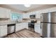 Modern kitchen with stainless steel appliances, white cabinets, and granite countertops at 2184 Pemberton Sw Rd, Atlanta, GA 30331
