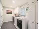 Well-lit laundry room features modern appliances, overhead cabinets, and sleek tile flooring at 2772 Dunnington Cir, Atlanta, GA 30341