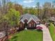 Brick home with manicured lawn, mature trees, and a long driveway at 6060 Masters Club Dr, Suwanee, GA 30024