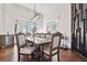 Elegant dining room featuring hardwood floors, modern light fixture, and windows overlooking outdoor scenery at 6060 Masters Club Dr, Suwanee, GA 30024