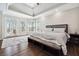 Main bedroom features tray ceilings, large windows, a sitting bench, and hardwood floors at 6060 Masters Club Dr, Suwanee, GA 30024