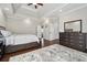 Hardwood floors, white tray ceilings, ensuite access, and dresser in this main bedroom at 6060 Masters Club Dr, Suwanee, GA 30024