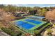 A community offers green and blue tennis courts, surrounded by manicured landscaping at 6060 Masters Club Dr, Suwanee, GA 30024