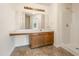 Bright bathroom featuring a large mirror, extended countertop, wood cabinets, and a stand-up shower at 9992 Neuchatel Cres, Jonesboro, GA 30238