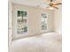 Bright bedroom features neutral carpet, two windows offering natural light, and a ceiling fan at 9992 Neuchatel Cres, Jonesboro, GA 30238