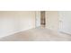 Bedroom with neutral walls and carpet that lead to an open doorway with stairs visible at 9992 Neuchatel Cres, Jonesboro, GA 30238