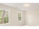 Bright bedroom with two windows bringing in natural light and neutral walls and carpet at 9992 Neuchatel Cres, Jonesboro, GA 30238