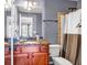 Bathroom featuring granite counters, dual sinks, and decorative shower curtain at 1829 Appaloosa Mill Ct, Buford, GA 30519