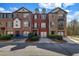 View of townhouses with brick and siding, garages, and small landscaped yards at 1829 Appaloosa Mill Ct, Buford, GA 30519