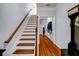 Bright staircase with wood treads and white risers, wood railing, and an open hallway at 1829 Appaloosa Mill Ct, Buford, GA 30519