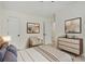 Well-lit bedroom with modern furnishings, including a stylish dresser and a comfortable armchair at 2864 Parkway Close, Lithonia, GA 30058