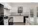 Modern kitchen featuring white cabinetry, granite countertops, and black appliances at 2864 Parkway Close, Lithonia, GA 30058