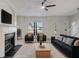 Living room featuring a fireplace, large TV, furniture and ceiling fan at 2864 Parkway Close, Lithonia, GA 30058
