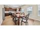 Bright dining room with dark wood table and chairs and modern kitchen in the background at 1408 Seals Rd, Dallas, GA 30157