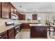 Modern kitchen featuring stainless steel appliances, granite counters and dark wood cabinets at 1408 Seals Rd, Dallas, GA 30157