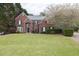 Charming two-story brick home with a well-manicured lawn and blooming tree at 2555 Stonevalley Ln, Cumming, GA 30041