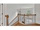 Upstairs hallway boasts wood railing with black iron spindles and views of the front windows and living room at 2555 Stonevalley Ln, Cumming, GA 30041