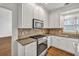 Bright kitchen boasts white cabinets, granite countertops, stainless steel appliances, and tile backsplash at 2555 Stonevalley Ln, Cumming, GA 30041