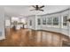 Open-concept living room with kitchen view, hardwood floors, large windows, and ample natural light at 2555 Stonevalley Ln, Cumming, GA 30041
