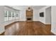 Spacious living room with stone fireplace, hardwood floors, large windows, and a ceiling fan at 2555 Stonevalley Ln, Cumming, GA 30041