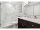 Bathroom featuring glass shower with marble-style tile, dark cabinets, and bright white countertops at 2877 Elliott Ne Cir, Atlanta, GA 30305