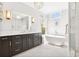 Bright bathroom featuring a soaking tub, glass shower, white marble counters, and dark wood cabinets at 2877 Elliott Ne Cir, Atlanta, GA 30305
