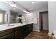 Bathroom features a double sink vanity with updated fixtures and wood-look floors at 3894 Dunaire Dr, Stone Mountain, GA 30083