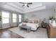 Spacious bedroom boasts a tray ceiling, a ceiling fan and lots of natural light at 3894 Dunaire Dr, Stone Mountain, GA 30083