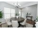 Bright dining room features a modern chandelier and a round wood table with seating for six at 3894 Dunaire Dr, Stone Mountain, GA 30083