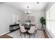 Dining area featuring a round table, six chairs, modern lighting, and neutral decor at 3894 Dunaire Dr, Stone Mountain, GA 30083