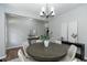 Bright dining room features a modern chandelier and a round wood table with seating for six at 3894 Dunaire Dr, Stone Mountain, GA 30083