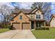 Two-story home with a brick and tan exterior, attached garage, and manicured lawn at 3894 Dunaire Dr, Stone Mountain, GA 30083
