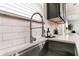 Close-up of the stainless steel sink with modern faucet, tiled backsplash, and light countertop at 3894 Dunaire Dr, Stone Mountain, GA 30083