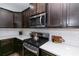 Close-up of kitchen featuring stainless steel microwave, dark wood cabinets and white countertops at 3894 Dunaire Dr, Stone Mountain, GA 30083