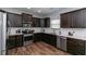 Modern kitchen featuring stainless steel appliances, white backsplash, and dark wood flooring at 3894 Dunaire Dr, Stone Mountain, GA 30083