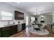 Well-lit kitchen featuring dark cabinets, stainless steel appliances, and an adjoining dining and living area at 3894 Dunaire Dr, Stone Mountain, GA 30083