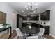 Charming eat-in kitchen featuring dark cabinetry, stainless appliances, and elegant lighting at 3894 Dunaire Dr, Stone Mountain, GA 30083