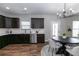Open concept kitchen with dark cabinetry, stainless appliances, and adjacent dining area with modern lighting at 3894 Dunaire Dr, Stone Mountain, GA 30083