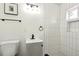 Bathroom with white tiled shower, toilet, and vanity sink with dark fixtures at 417 Lynnhaven Sw Dr, Atlanta, GA 30310