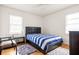Cozy bedroom featuring hardwood floors, a modern bed frame, and bright natural light from two large windows at 417 Lynnhaven Sw Dr, Atlanta, GA 30310