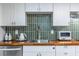 Close up on stainless steel sink and appliances in an updated kitchen with green backsplash at 417 Lynnhaven Sw Dr, Atlanta, GA 30310