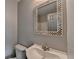 Bathroom featuring decorative tiled-mirror, white toilet, and sink at 5987 Turfway Park Ct, Sugar Hill, GA 30518