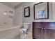Bathroom with a white tiled wall, dark cabinet, and a framed mirror at 5987 Turfway Park Ct, Sugar Hill, GA 30518
