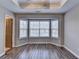 Bright bedroom with hardwood floors, a tray ceiling, and large windows at 5987 Turfway Park Ct, Sugar Hill, GA 30518