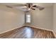 This bedroom features wood-look floors, a ceiling fan, and a window at 5987 Turfway Park Ct, Sugar Hill, GA 30518