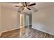 Bedroom featuring wood-look floors, ceiling fan, and adjacent bathroom and closet doors at 5987 Turfway Park Ct, Sugar Hill, GA 30518