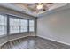 Well-lit bedroom featuring hardwood floors, a ceiling fan, and wide windows at 5987 Turfway Park Ct, Sugar Hill, GA 30518