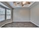 Light-filled bedroom featuring hardwood floors, a fan, and wide windows at 5987 Turfway Park Ct, Sugar Hill, GA 30518